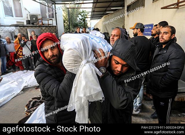 19 December 2023, Palestinian Territories, Rafah: Palestinians carry the wrapped body of a Palestinian, killed in Israeli bombardment