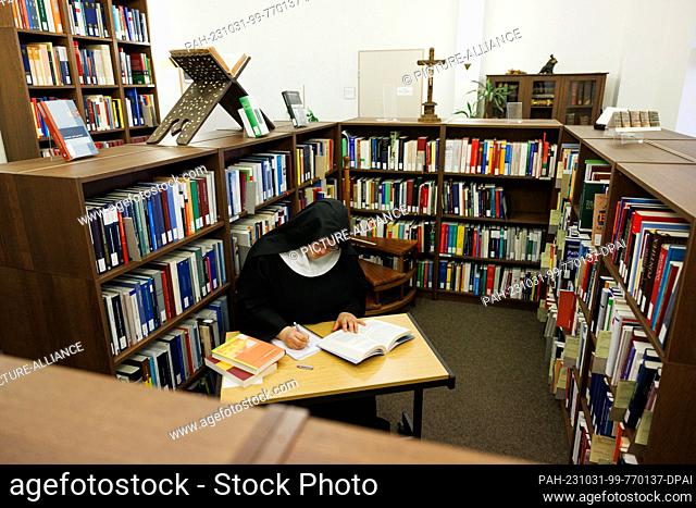 PRODUCTION - 20 October 2023, Lower Saxony, Osnabrück: Sister Josefine sits in a posed situation in a room of the Osnabrück Diocesan Library