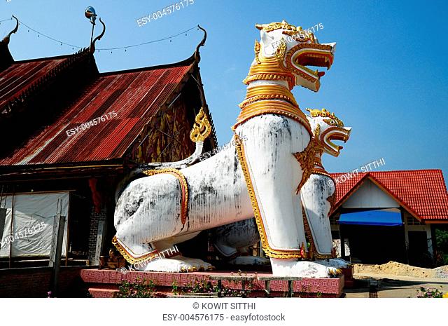 antique guardian lion sculpture in front of the temple, thailand