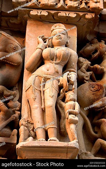 Statue of graceful lady applying mascara (eye-lotion) on her eye at Jain Temple in Khajuraho, Madhya Pradesh, India, Asia