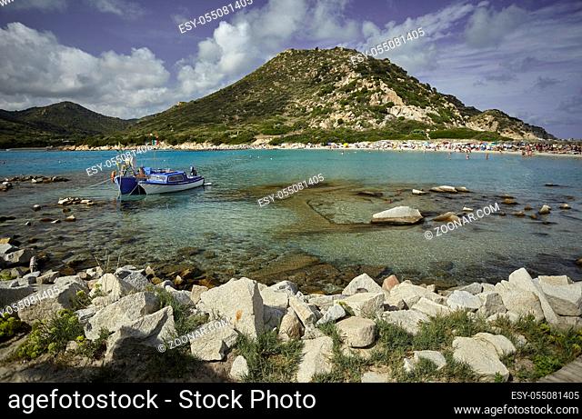Beautiful view of Punta Molentis, a natural beach on the southern coast of Sardinia with a couple of small fishing boats moored on the shore