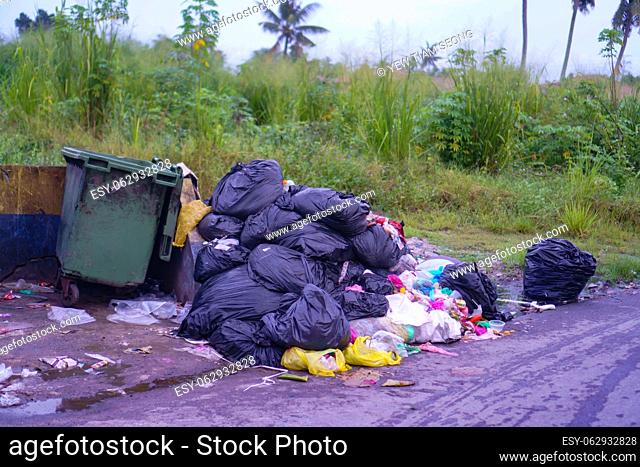 Black rubbish bag stack together beside the dustbin at outdoor