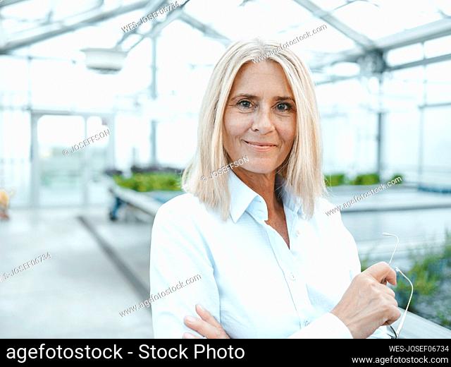 Blond biologist in plant nursery