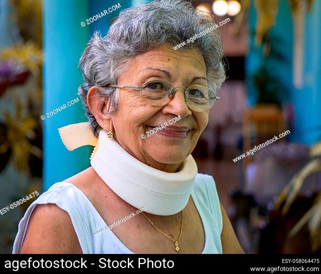Smiling elderly woman wearing homemade looking cervical immobilizer collar