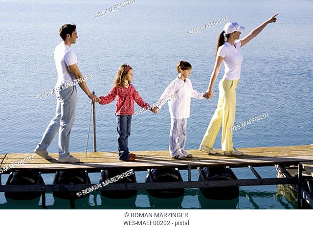 Familiy standing on jetty, holding hands
