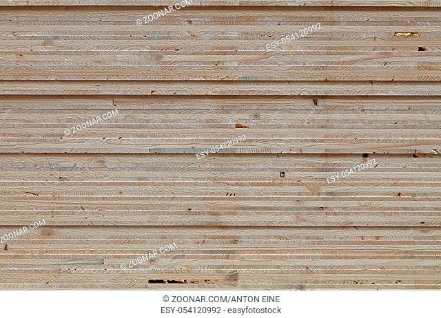 Background texture of wooden OSB board butt ends stacked, close up, low angle view