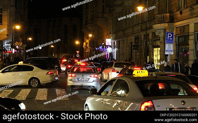 Dozens of taxi cars and noisy people on the streets in front of the night bars in the Old Town on the night of December 16, 2023