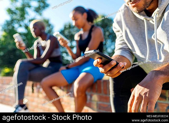 Athlete using mobile phone on sunny day