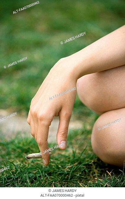 Woman holding a marijuana joint, cropped