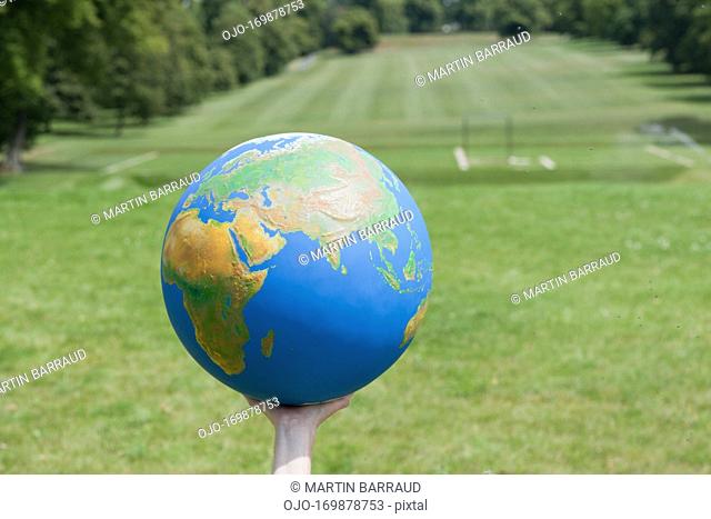 Hand holding large globe outdoors