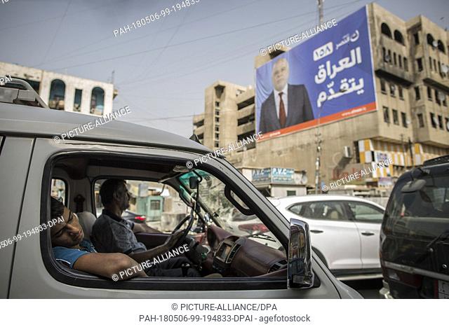 A picture made available on 07 May 2018 shows a man sleeping in a car backdropped by a campaign poster of Iraqi Prime Minister Haider al-Abadi in Baghdad, Iraq