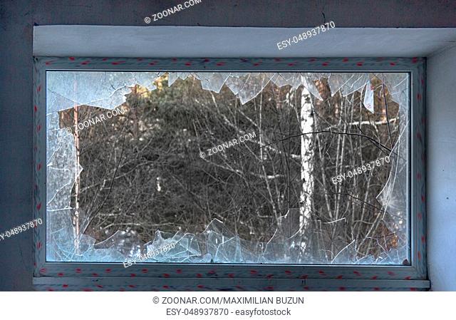 glass breakage, danger. big window with blue glass destruction