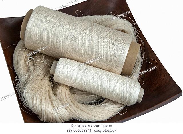Raw natural silk yarn skein and bobbins in wooden