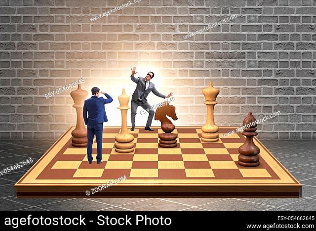 The businessman in large chess board in strategy concept