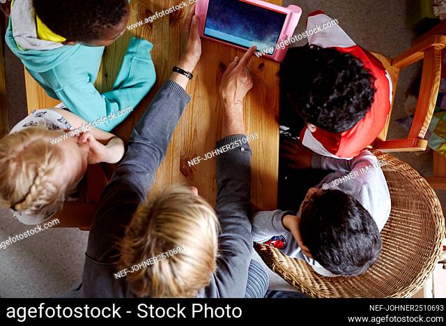 Children in classroom looking at digital tablet