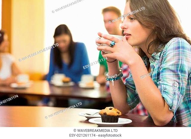 Female having coffee and muffin at coffee shop