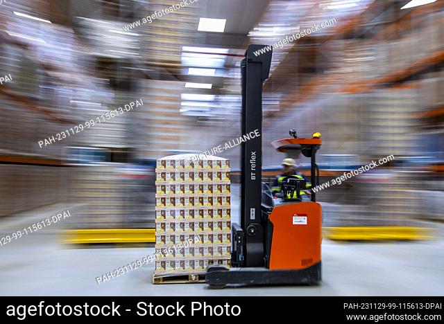 PRODUCTION - 21 November 2023, Mecklenburg-Western Pomerania, Rostock: Forklift trucks transport pallets with stored goods to the storage locations in the new...