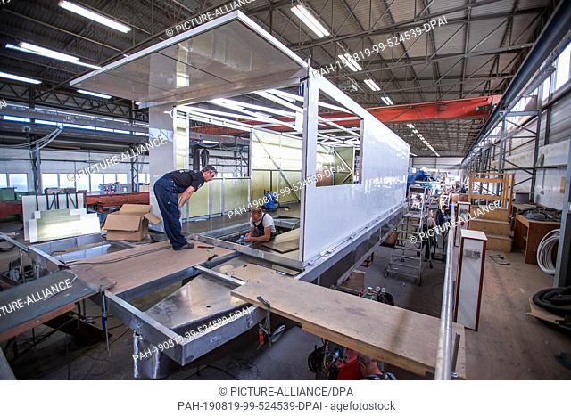 25 May 2019, Mecklenburg-Western Pomerania, Rechlin: A houseboat is overhauled in the Kuhnle shipyard shipbuilding hall. The boats intended for charter tours on...