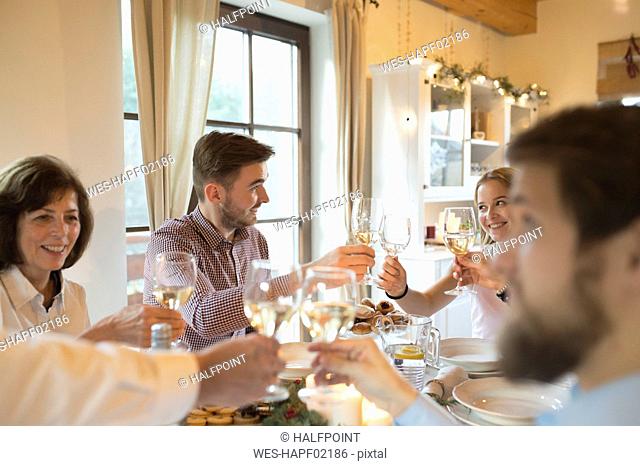 Family clinking glasses at Christmas dinner