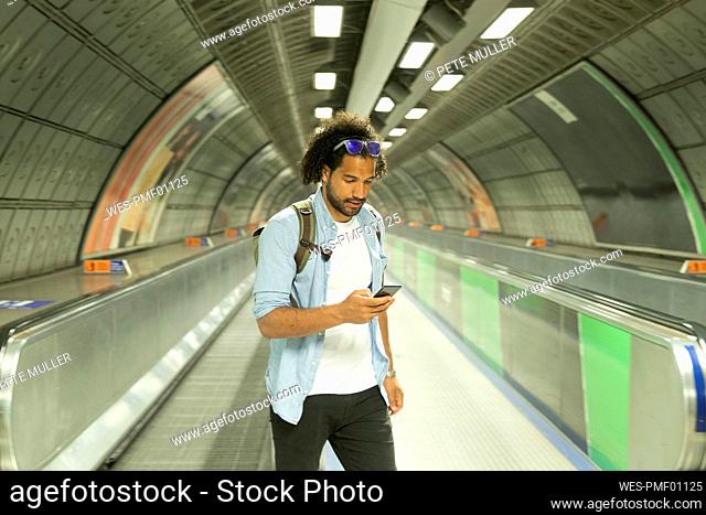 Portrait of young man looking at mobile phone, London, UK