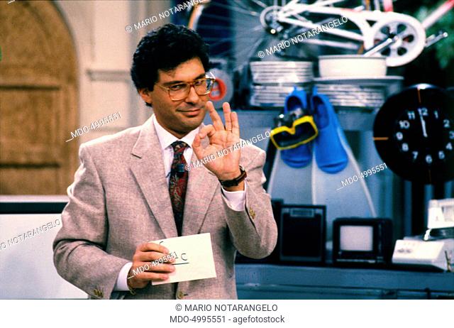 Italian TV host Fabrizio Frizzi holding an envelope in the TV show I fatti vostri. 1990