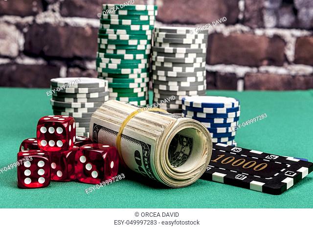 Dice, money and chips on green table