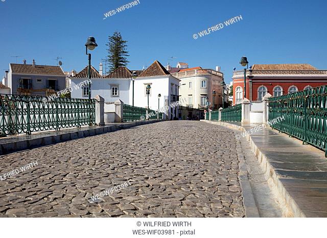 Empty old bridge against buildings in Tavira, Portugal