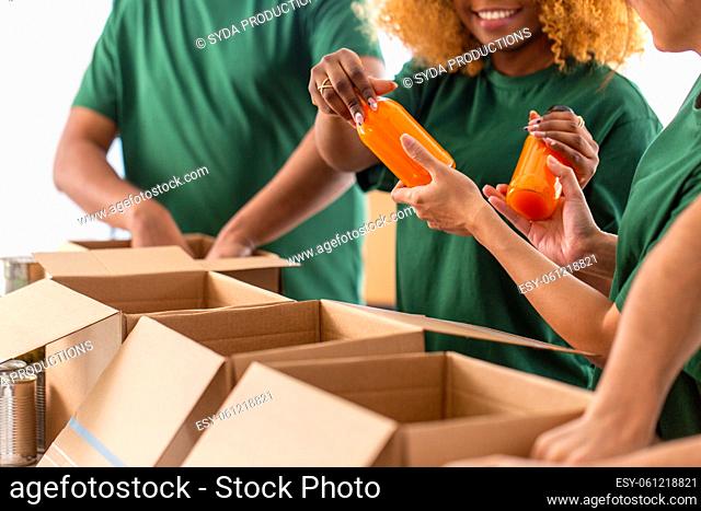 close up of volunteers packing food in boxes