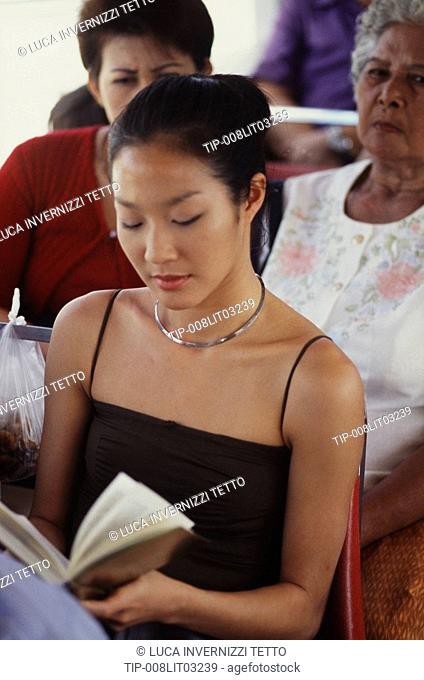 Girl reading on the Chaopraya express boat, bangkok, Thailand