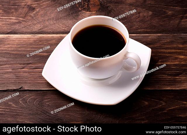 White cup of coffee with on a wooden table