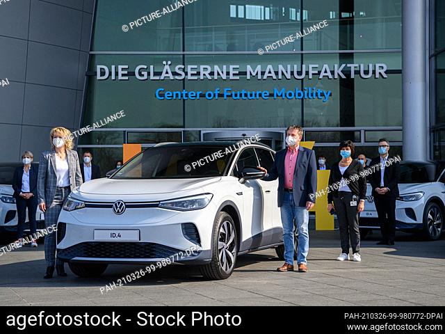 26 March 2021, Saxony, Dresden: Customer Jacqueline Heyer-Mertens (l) and her husband Mario Heyer from Suhl stand in front of the Transparent Factory in Dresden...