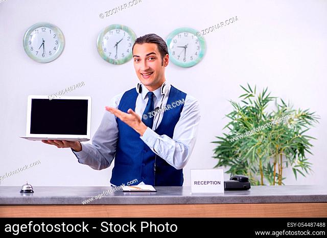 The young man receptionist at the hotel counter
