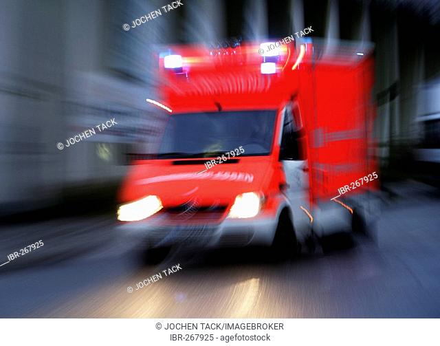 DEU Germany: Essen fire brigade. Ambulance on the way to an emergency with flashing blue lights.|