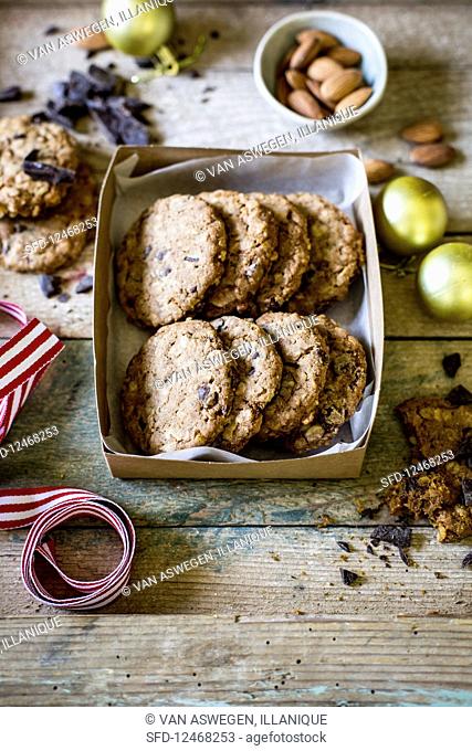 Festive chocolate chip, almond and oat cookies as a gift for christmas on rustic wooden surface