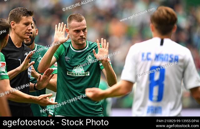 29 August 2021, Bremen: Football: 2. Bundesliga, Werder Bremen - Hansa Rostock, Matchday 5. Werder's Marvin Ducksch dirkuteirt with referee Daniel Siebert and...