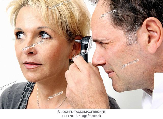 Doctor's surgery, doctor examining a patient's ear canal using an ear speculum