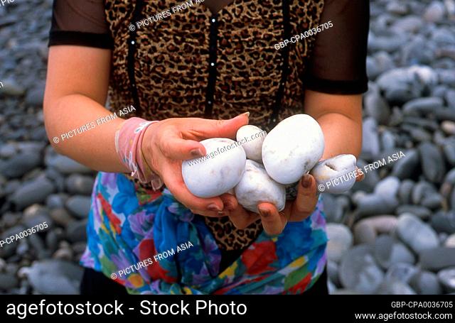 Taiwan: An Amis woman holding sea-washed marble pebbles, East Coast National Scenic Area.<br/><br/> The Amis (also Ami or Pangcah) are an Austronesian ethnic...