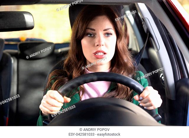Portrait Of A Shocked Young Woman Driving Car