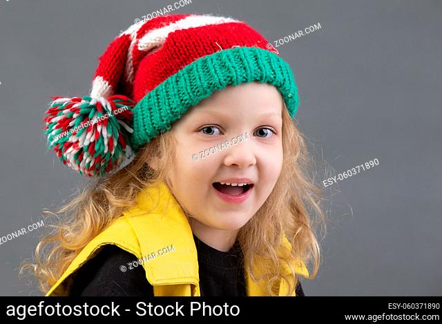 Funny little girl in a Christmas hat. Portrait of a cheerful and happy child