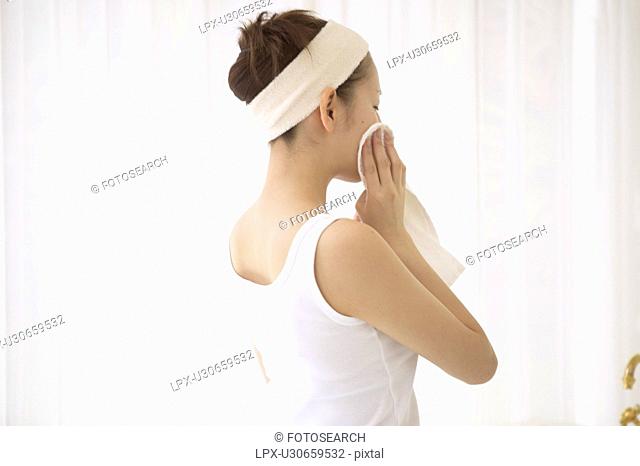 Young woman drying face
