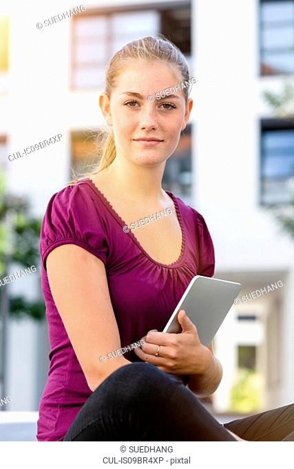 Young woman with digital tablet in park