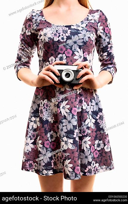 A close up shot of a girl in a colorful dress, holding a vintage camera, isolated on white background