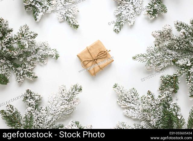 Christmas still life. Spruce branches form a frame with gift box in the middle