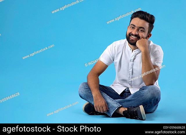 A HAPPY BEARDED MAN POSING IN FRONT OF CAMERA
