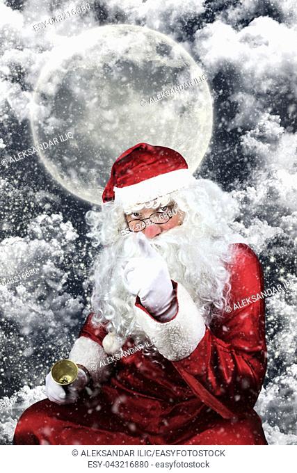 Santa Claus in the Christmas Night , with Sky full of Stars, Snow, Clouds and The Moon in the Background