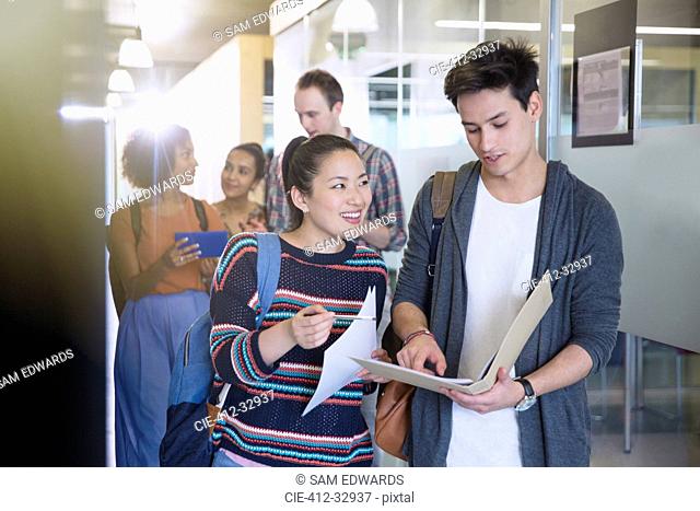 College students discussing homework in corridor