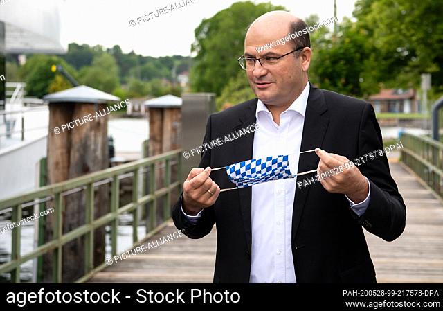 28 May 2020, Bavaria, Starnberg: Albert Füracker (CSU), Minister of Finance and Homeland Affairs of Bavaria, is standing with a mouthguard on a jetty at Lake...