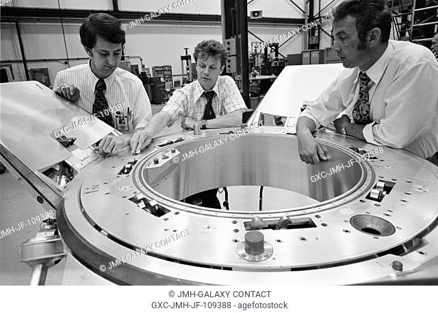 Three Apollo-Soyuz Test Project (ASTP) engineers look over a Soyuz spacecraft docking system prior to an ASTP docking mechanism fitness test conducted in...