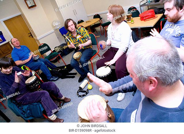 A group of visually impaired people playing drums in a drumming workshop at the NRSB activity day at their centre on Ortzen Street