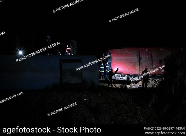 26 March 2021, Egypt, Tahta: Workers inspect the scene of damaged train cars after two passenger trains collided near Tahta in Sohag Governorate